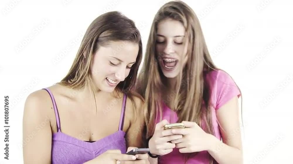 Cute teenagers texting messages with cell phone isolated Cute teenagers texting messages with cell phone isolated
