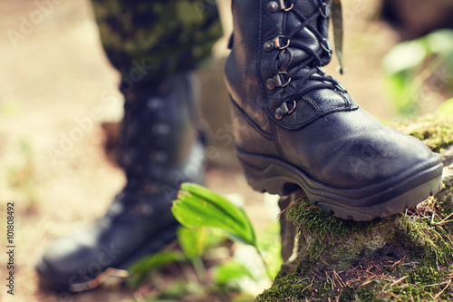 close up of soldier feet with army boots in forest