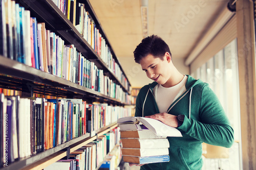 happy student or man with book in library