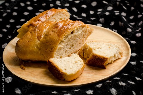 Fresh bread on wooden plate and fabric