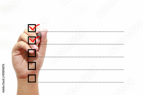 Businessman checking mark on checklist with marker over white