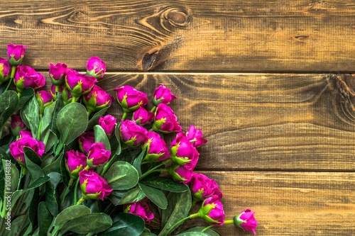 Pink roses on wood background with copyspace