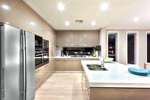 A modern kitchen with refrigerator and fixed to the wall with ca