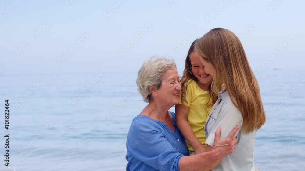 Multi generation family hugging on the beach Multi generation family hugging on the beach