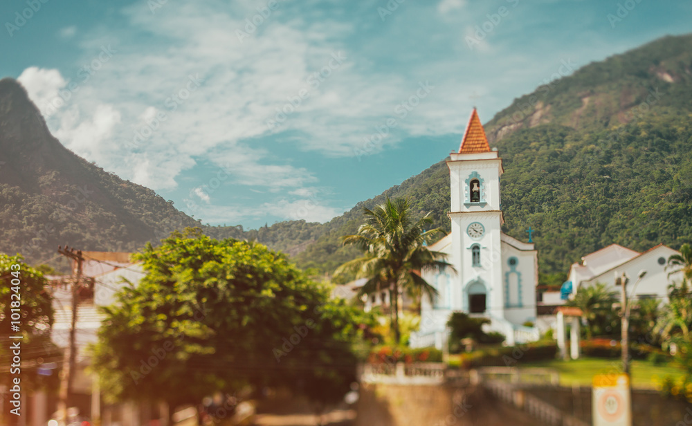 Church with bell tower in the village, wooded mountains in the background, Brazil, tilt shift shooting