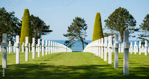 Alignement de croix dans le cimetière militaire de Colleville-sur-Mer, Normandie, France. Avec la mer et des arbres en arrière-plan. photo