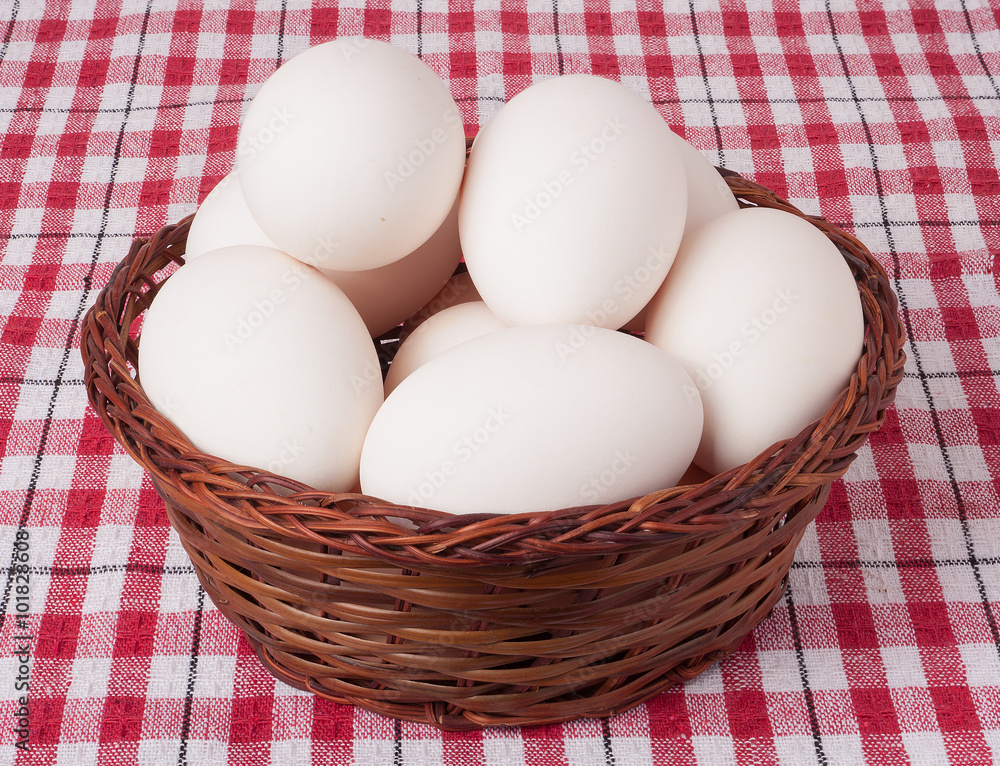 eggs in a wicker basket on red checkered background eggs in a wicker basket on red checkered background