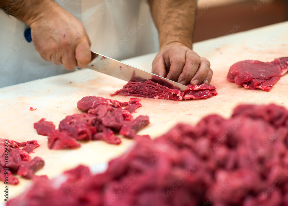 Fotografie Hands preparing cuts of raw meat