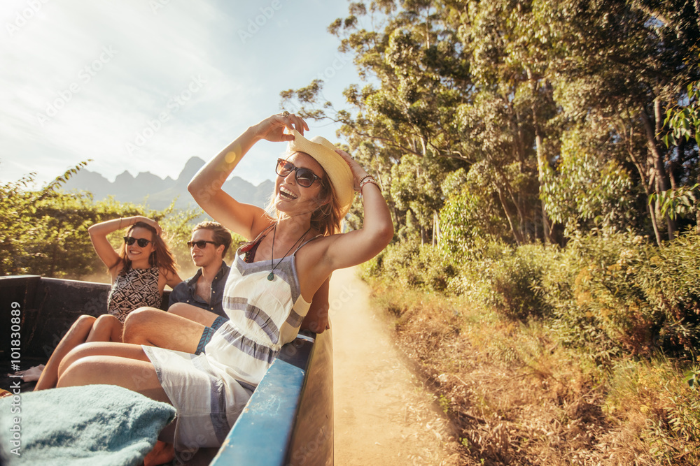 Φωτογραφία Cheerful young woman with friends in the back of a pickup truck