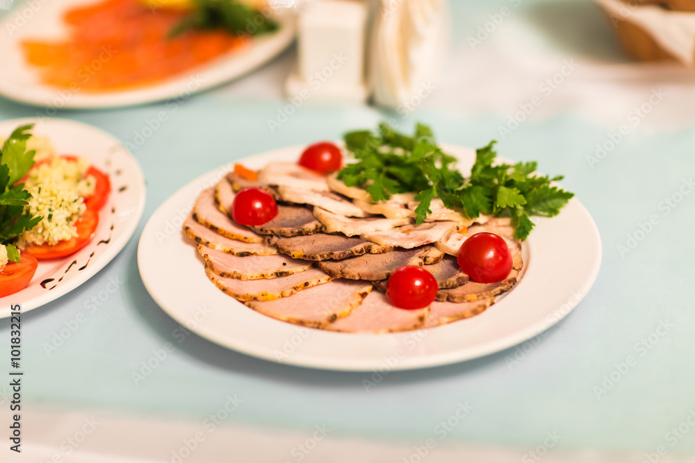 smoked ham with cherry tomatoes  on the table