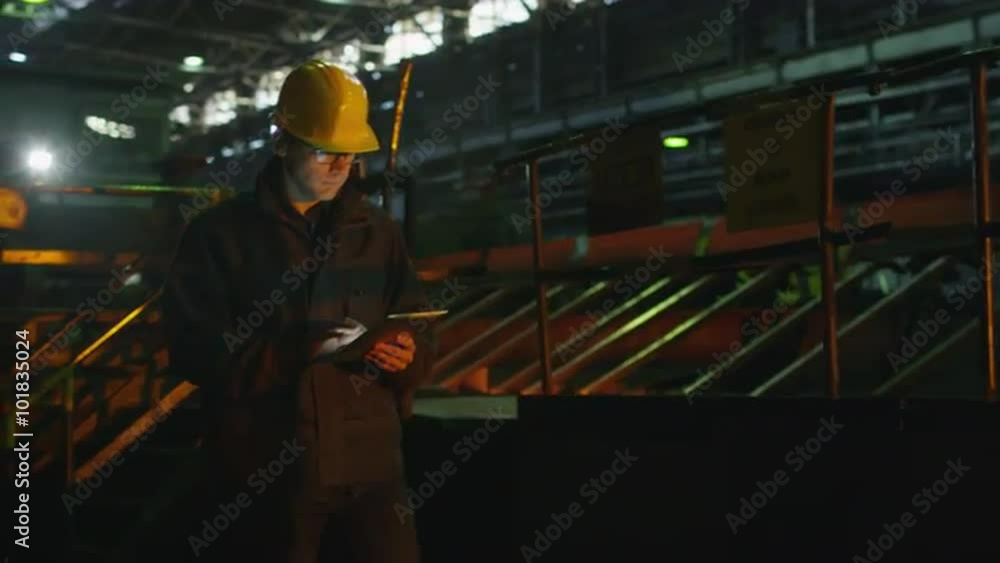 Engineer in hard Hat using Tablet PC in Foundry. Industrial Environment. Shot on RED Cinema Camera. Engineer in hard Hat using Tablet PC in Foundry. Industrial Environment. Shot on RED Cinema Camera.