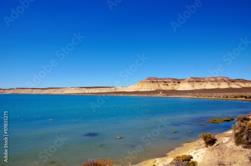 Blue Ocean in front of the brown hill of Cerro Avanzado after Punta Loma in Argentina