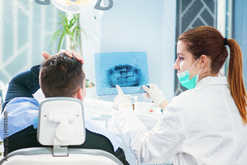 Tableau sur toile Doctor and patient looking at roentgen of human jaw
