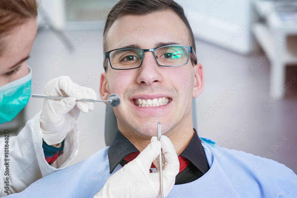 Patient smiling at dentist office. Doctor examining a patient. Patient smiling at dentist office. Doctor examining a patient.