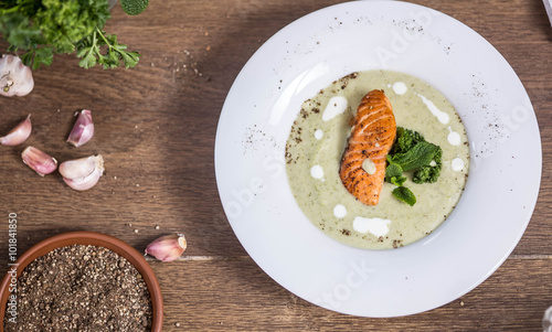 Cream of broccoli soup with salmon top view a wooden background