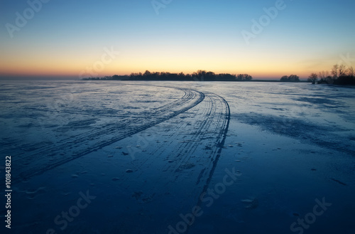 frozen lake  traces of wheels on ice  dawn.