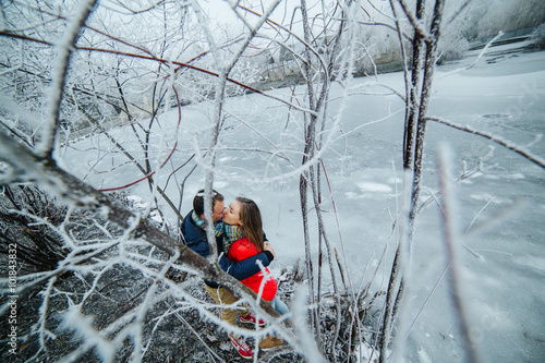 beautiful couple posing near a frozen river photo