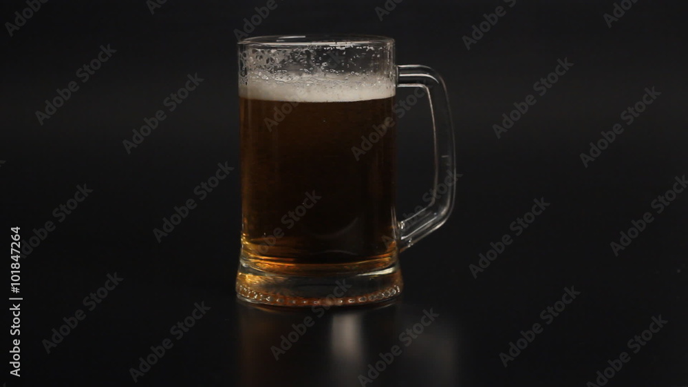 light wheat beer glass is poured into a glass on a black background light wheat beer glass is poured into a glass on a black background