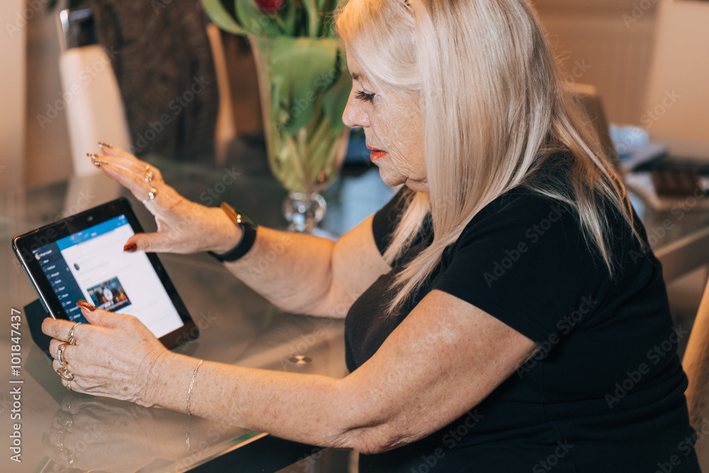Fotografie woman 65-70 years old using ipad tablet