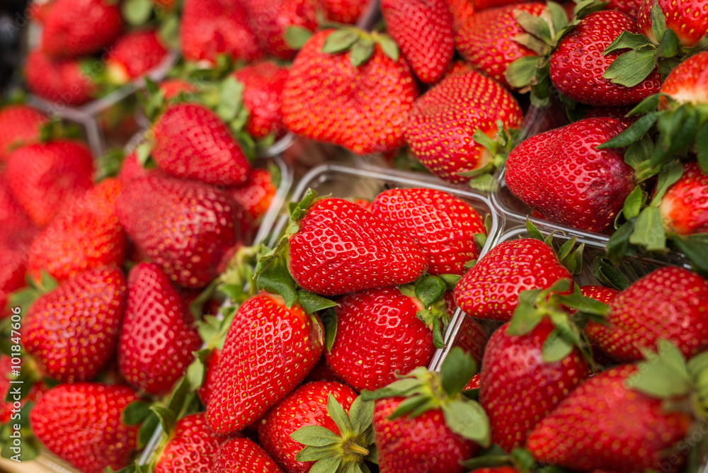 Fresh red strawberries arranged in baskets ready for sale at marketplace. Shallow depth of field. Fresh red strawberries arranged in baskets ready for sale at marketplace. Shallow depth of field.