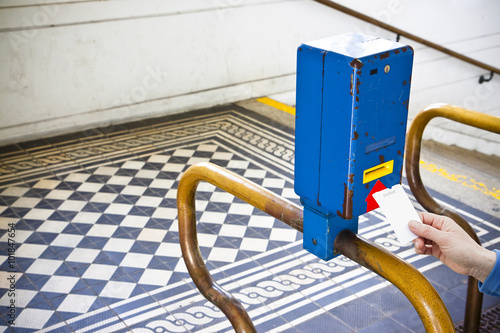 Woman's hand inserting a ticket in a colored obliterator photo