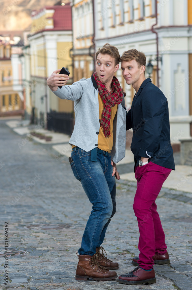 Cheerful day of twin brothers. Two stylish and handsome adult tw Cheerful day of twin brothers. Two stylish and handsome adult tw