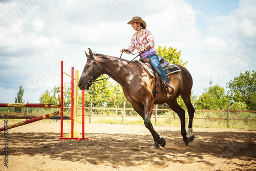 Western cowgirl woman training riding horse. Sport