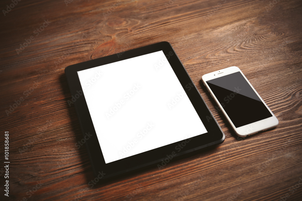 Modern mobile phone and tablet on wooden background Modern mobile phone and tablet on wooden background