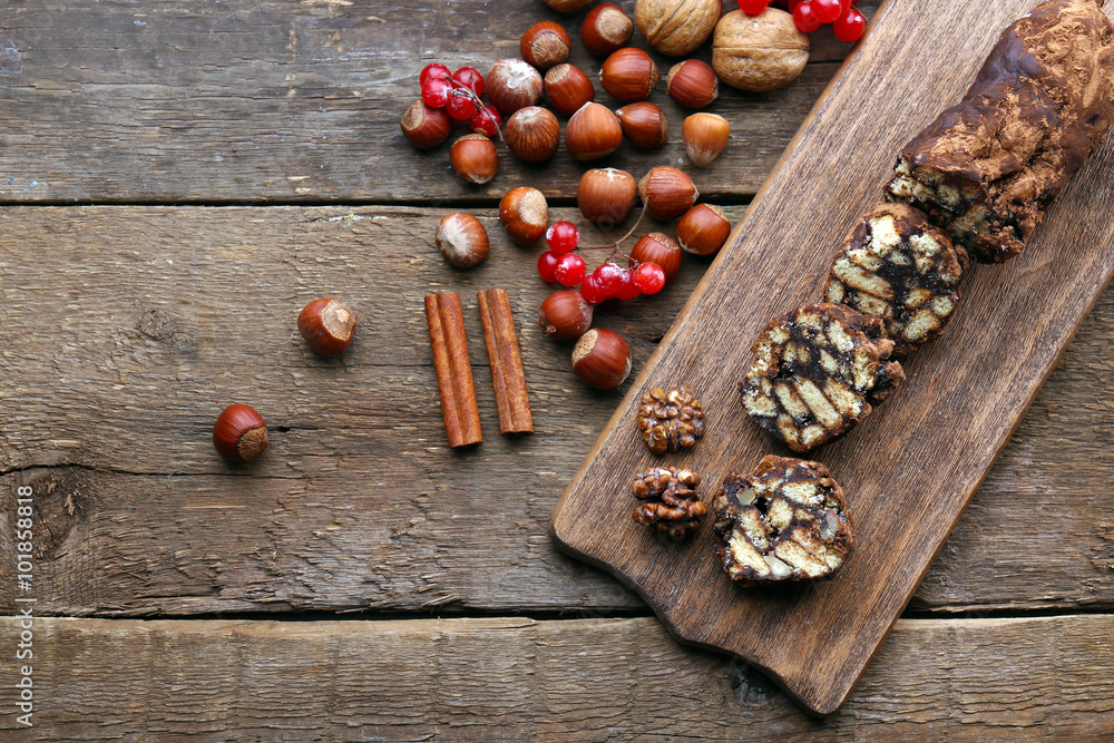 Chocolate salami on a chopping board over wooden background Chocolate salami on a chopping board over wooden background