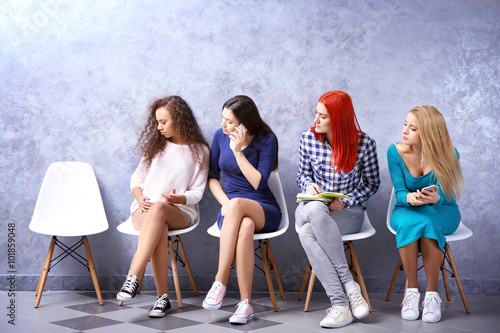Young girls sitting on a ch...