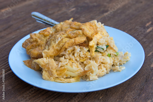 Pork fried rice with omelet on wood table