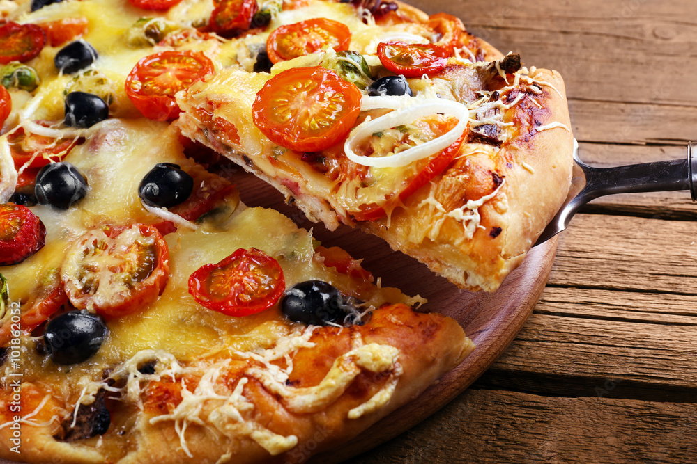 Sliced fresh pizza on wooden table closeup Sliced fresh pizza on wooden table closeup