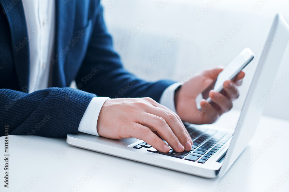 Businessman using laptop and mobile phone Businessman using laptop and mobile phone