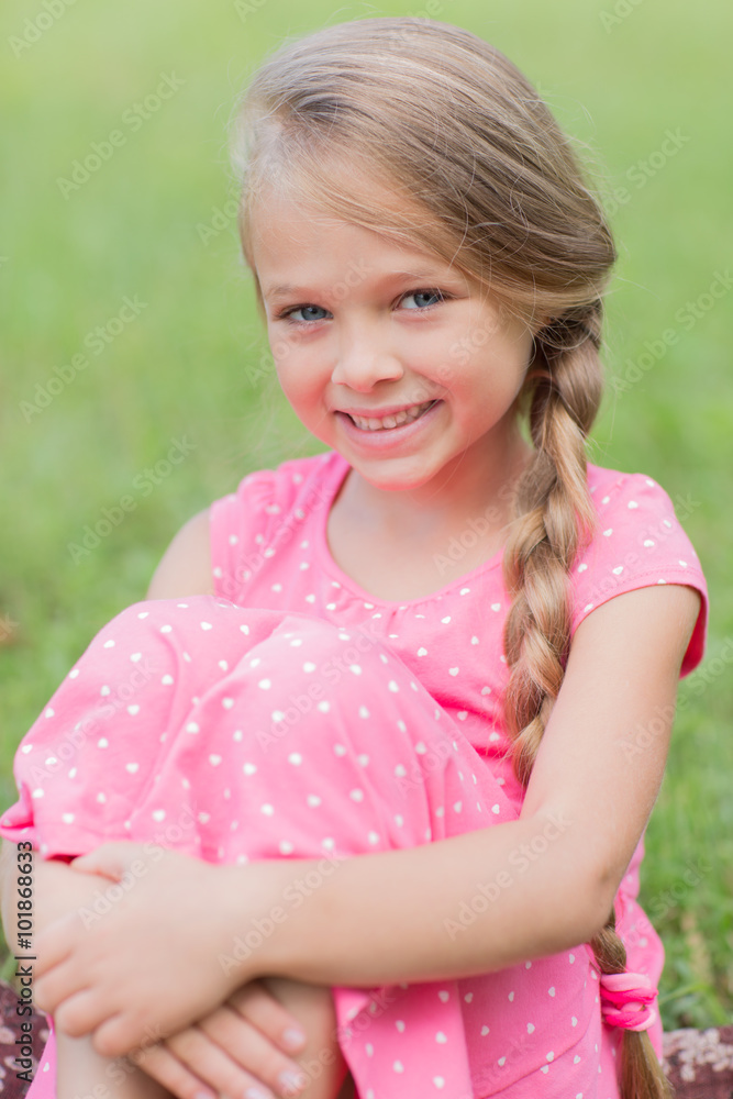 Girl with a lovely smile sitting on grass Girl with a lovely smile sitting on grass