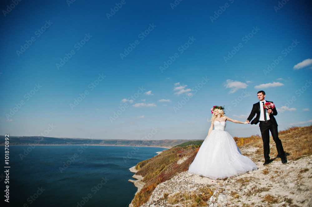 Charming bride in a wreath and elegant groom on landscapes of mo