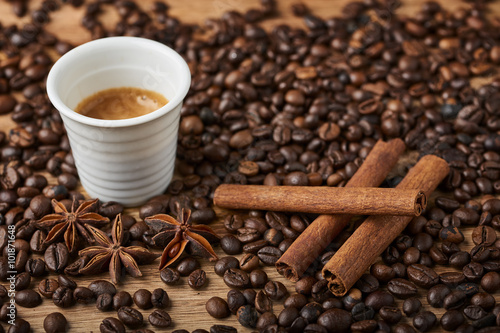 coffee cup, cinnamon and star anise on coffee beans
