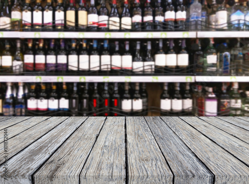 Wood table and wine Liquor bottle on shelf  Blurred background