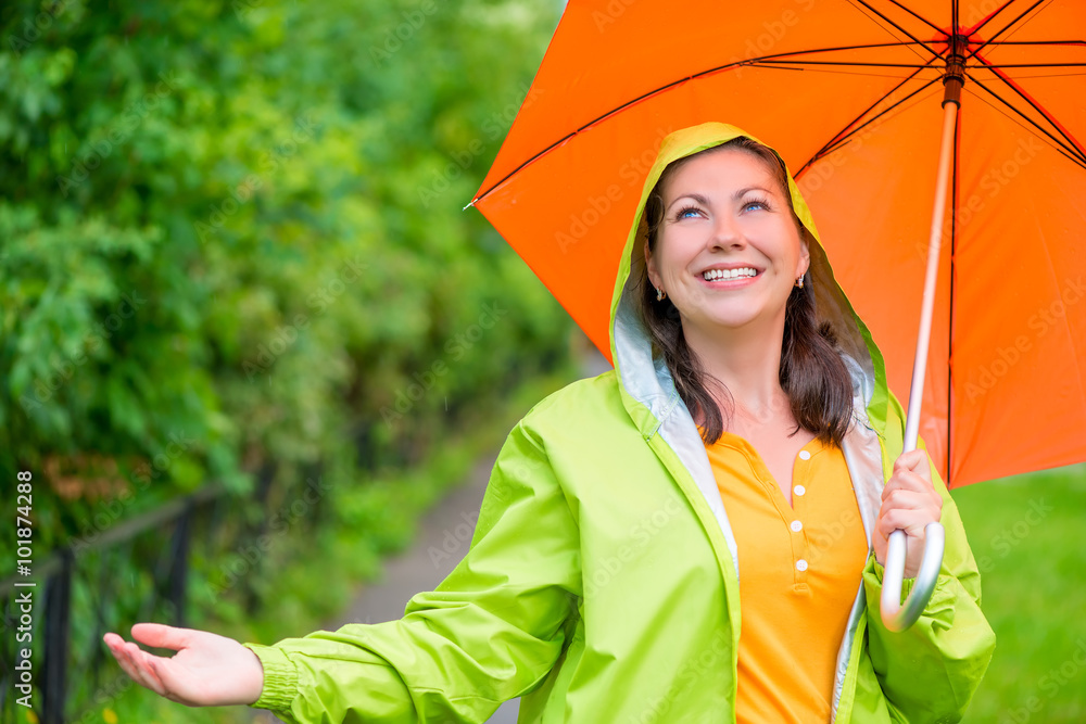 Φωτογραφία portrait of a beautiful girl with an umbrella and a raincoat on