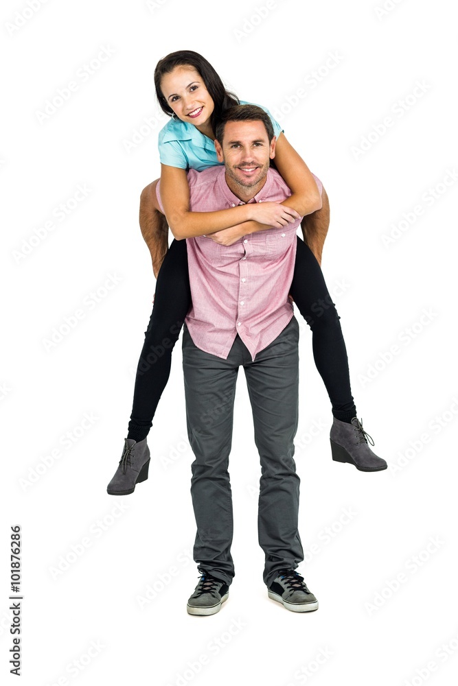 Smiling man giving piggy back to his girlfriend Smiling man giving piggy back to his girlfriend