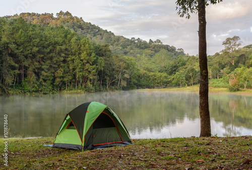 Green camping tent with fog over lake with beautiful view of pine tree forest at Pang Oung national park in Mae Hong Son, Thailand