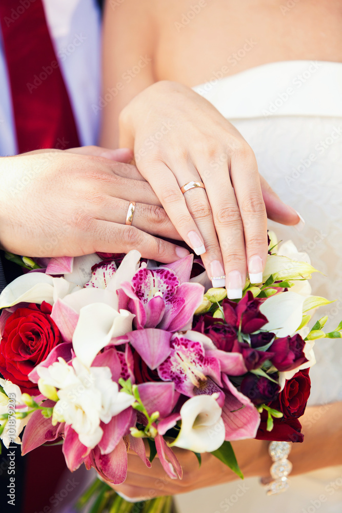 hands of groom and bride on a wedding bouquet hands of groom and bride on a wedding bouquet