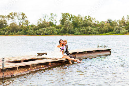 Beautiful bride and groom by a lake or river