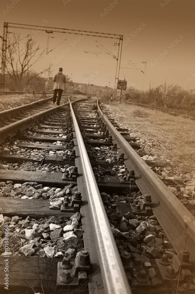 Young man walking on rail road