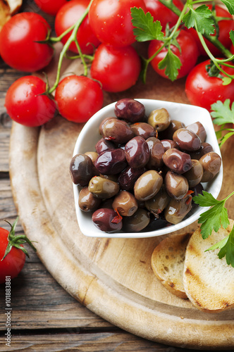 Olive with tamato and parsley on the wooden table