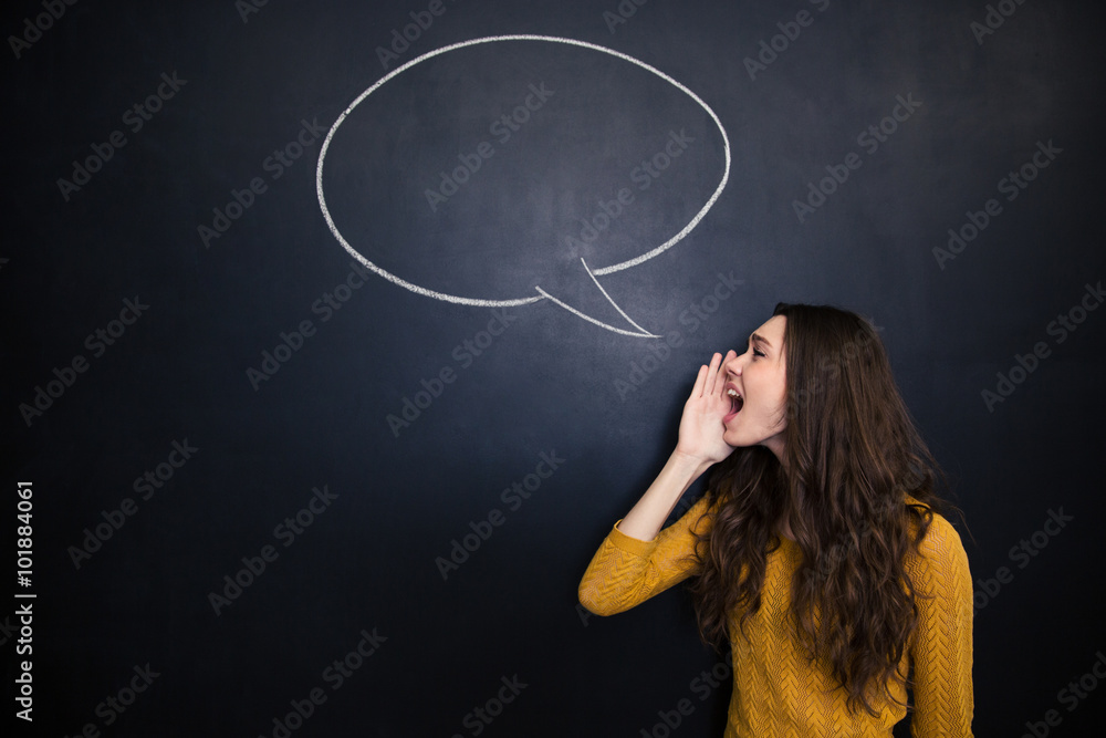 Φωτογραφία Charming woman screaming against background of chalkboard with speech bubble