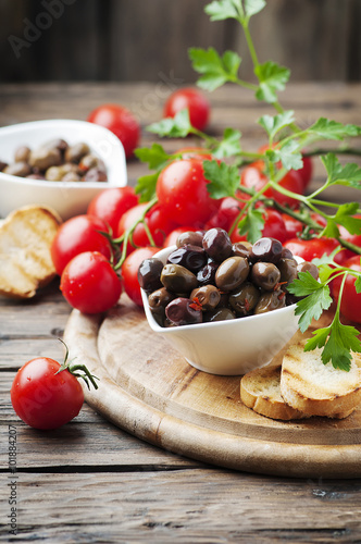 Olive with tamato and parsley on the wooden table