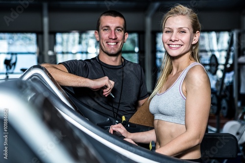 Fit woman with trainer using treadmill 