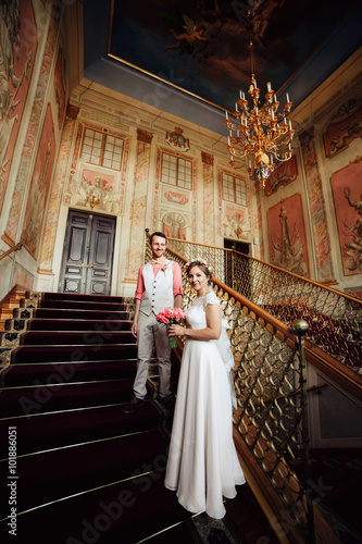 Happy stylish couple on background luxurious interior of the amazing castle.