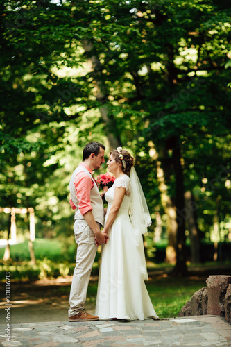 Bride and groom at wedding Day walking Outdoors on green nature.