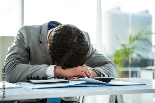Businessman lying on his desk